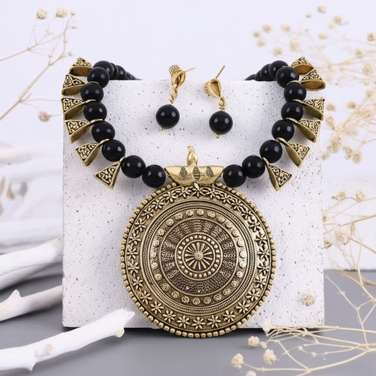 Elegant black and gold necklace paired with matching earrings
